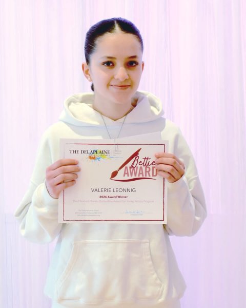 Coat, Sweatshirt, Person. Text: THE DELAPI AINE AWARD VALERIE LEONNIG