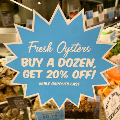 Shop, Bazaar, Person. Text: Fresh Oysters BUY A DOZEN, GET 20% OFF! WHILE SUPPLIES LAST WILD DIVERS $0.75 OYSTER