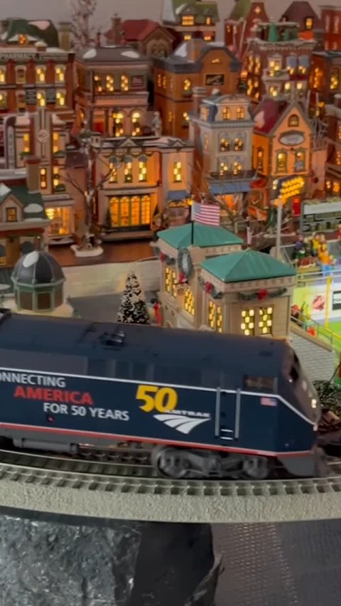 Toy, Train, Person. Text: NNECTING 50 AMERICA FOR 50 YEARS