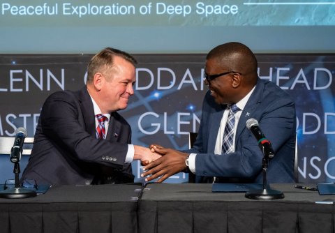 Crowd, Press Conference, People. Text: Peaceful Exploration of Deep Space HEAD DDA ENN GLE ST D