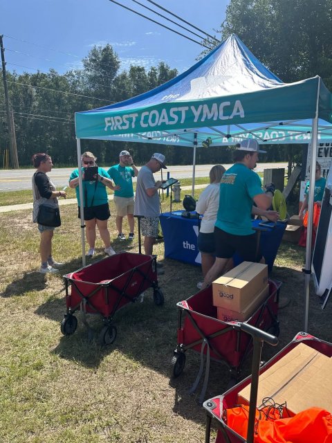 Handbag, Person, Glove. Text: the FIRST COAST YMCA the good