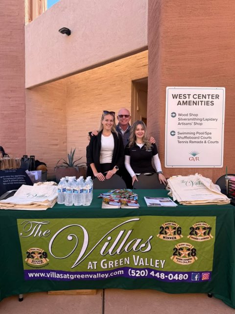 People, Desk, Plant. Text: WEST CENTER AMENITIES Wood Shop Swimming Pool/Spa Shuffleboard Courts Tennis Ramada &amp; Courts GVR The Villas WINNER AT GREEN VALLEY f