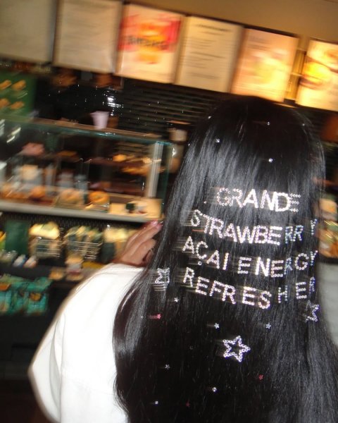 Black Hair, Person, Woman. Text: GRANDE STRAWBE RR AÇAI ENERGY REFR ES HER