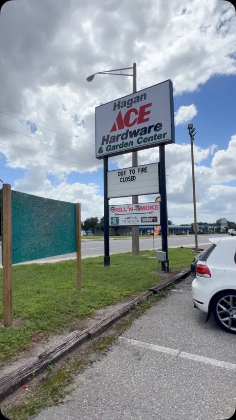 Advertisement, Car, Outdoors. Text: Hagan ACE Hardware &amp; Garden Center DUF TO FIRE CLOSED TRAEGER