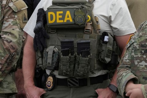 Vest, Baby, Person. Text: DEA