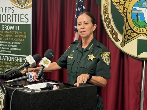 Microphone, Person, Police Officer. Text: RIFF'S COUNT GROWTH COMMITMENT TO PROVIDE H-LEVEL PUBLIC SERVICE ZE SMART TECHNOLOGY UTY PERSONNEL LATIONSHIPS ILL REMAIN STEADFAS NEWS JAX